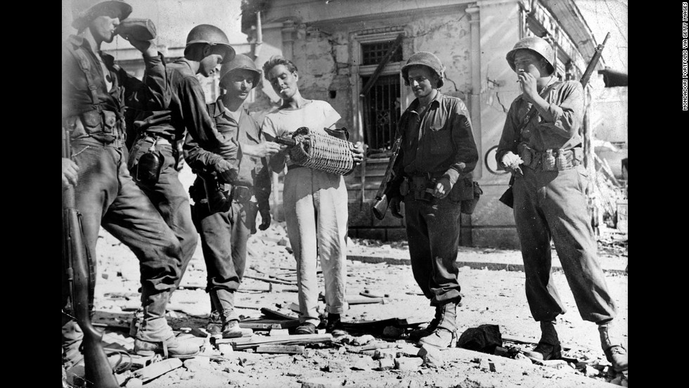 A Sicilian man offering wine to some U.S. soldiers of the Seventh Army. Messina, 16th August 1943 (Photo by Mondadori Portfolio via Getty Images)